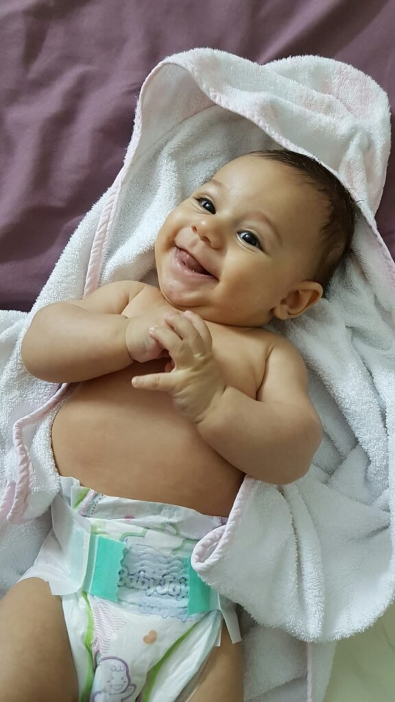 ทารกใส่ผ้าอ้อมยิ้มอยู่ในผ้าขนหนู